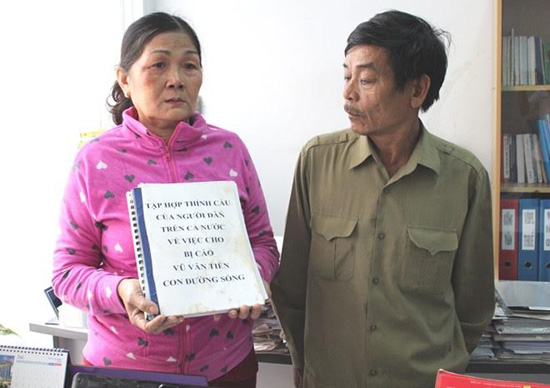 
Cha mẹ Vũ Văn Tiến (người bị Tòa án nhân dân tỉnh Bình Phước kết án tử hình) cầm trên tay cuốn sổ có 10.000 chữ ký của người dân xin cho Tiến một con đường sống.
