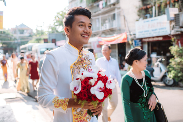 
Quang Tuấn diện áo dài họa tiết rồng, rạng rỡ cùng họ nhà trai đi rước dâu.
