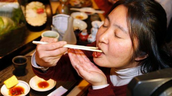 Người dân Nhật Bản ăn sushi. Ảnh: AP.