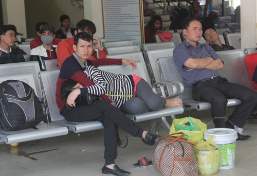 
Hành khách mệt mỏi chờ xe tại bến xe Vinh sáng 14/2. Ảnh: Phan Ngọc.
