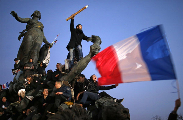 Một người đàn ông cầm chiếc bút chì khổng lồ khi tham gia tuần hành đoàn kết ở Paris ngày 11/1, sau loạt vụ tấn công tàn bạo nhằm vào tòa soạn báo trào phúng Charlie Hebdo, vụ giết một nữ cảnh sát ở Montrouge và bắt cóc con tin tại một siêu thị Do Thái ở Porte de Vincennes. (Ảnh: Reuters)