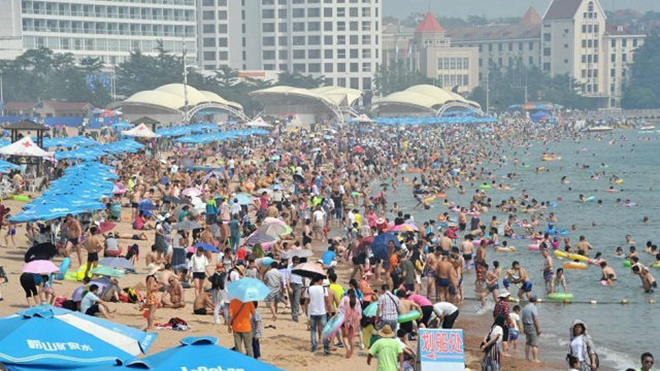 
Nhiệt độ lên cao hơn 30 độ C khiến các bãi biển ở thành phố Thanh Đảo, tỉnh Sơn Đông, chật kín du khách đến tắm.
