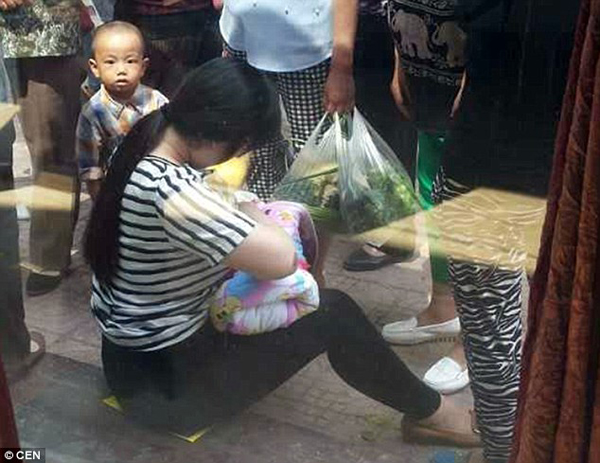 
Người phụ nữ này không ngần ngại vén áo cho em nhỏ bú khi nghe bé khóc vì khát sữa. Ảnh: CEN.
