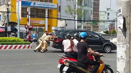 Cảnh sát giao thông đẩy ô tô chết máy giúp dân. Ảnh: Facebook.