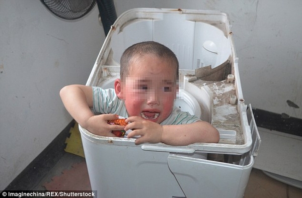 Cậu bé khóc nức nở vì bị mắc kẹt trong lồng sấy của chiếc máy giặt.