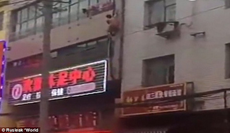 Người đ&agrave;n &ocirc;ng b&aacute;m v&agrave;o đường ống trước nh&agrave; để tr&egrave;o xuống.