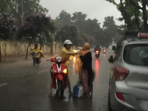 Khoảnh khắc cô gái che mưa cho bà cụ trong cơn mưa dông hiện thu hút hơn 53.000 like (thích) và 3.000 chia sẻ. Ảnh: Quan Tran.