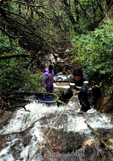 Lực lượng cứu hộ đu dây xuống thác nước mới có thể tiếp cận thi thể nạn nhân. Ảnh: Thanh Tuấn