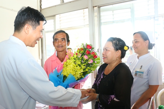 Phó giáo sưTrần Quyết Tiến, Phó Giám đốc Bệnh viện Chợ Rẫy tặng hoa chúc mừng ông Nén và gia đình trước lúc xuất viện. Ảnh: B.V