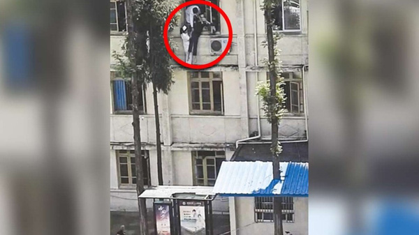 
Để cứu một bệnh nhân có ý định nhảy lầu tự tử, một nữ y tá đã liều mình trèo hẳn ra ngoài khung cửa sổ, đứng vắt vẻo trên cao.
