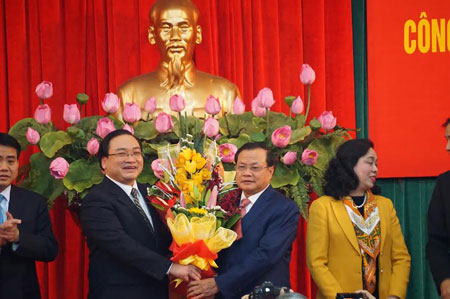 Ông Hoàng Trung Hải nhận hoa chúc mừng của ông Phạm Quang Nghị