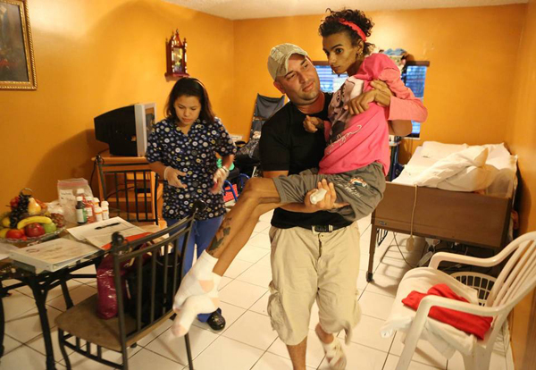 
Linda Perez được bố bế tại nhà hồi tháng 1/2014, 5 tháng sau khi cô tiến hành nâng ngực. Ảnh:Miami Herald
