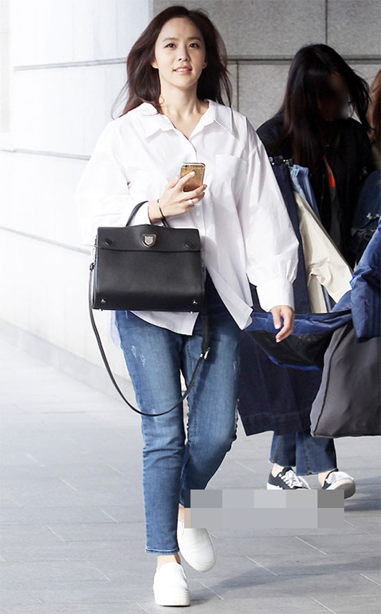Áo sơ mi trắng là món đồ không thể thiếu trong tủ đồ của bất cứ cô nàng nào. Park Ji Yoon diện quần jeans xanh, áo sơ mi trắng dáng thụng và túi xách đen, giày sneaker rất tinh tế.