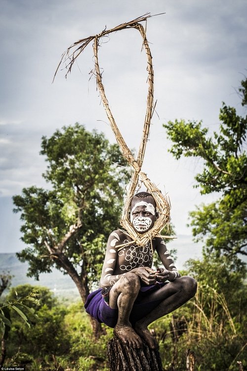 
Một cậu bé bộ tộc Suri dừng chân bên đường. Cách trang trí cơ thể của cậu quả khiến người ta khó hiểu.
