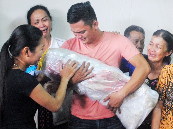 Người thân của thầy Tiên khóc nức nở khi ôm thi thể một trong hai bé chết cháy.Ảnh: Nhật Tân.