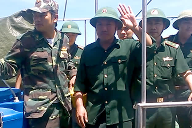 Phi công Nguyễn Hữu Cường vẫy tay chào đồng đội và mọi người có mặt khi được đưa về đất liền