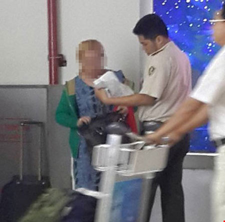 An ninh sân bay làm việc với mẹ của cháu bé. (Ảnh do nhân chứng cung cấp)