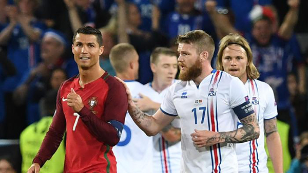 
Gunnarsson chạy theo C. Ronaldo để đề nghị đổi áo sau trận hòa 1-1 giữa Iceland và Bồ Đào Nha. Ảnh: AFP.
