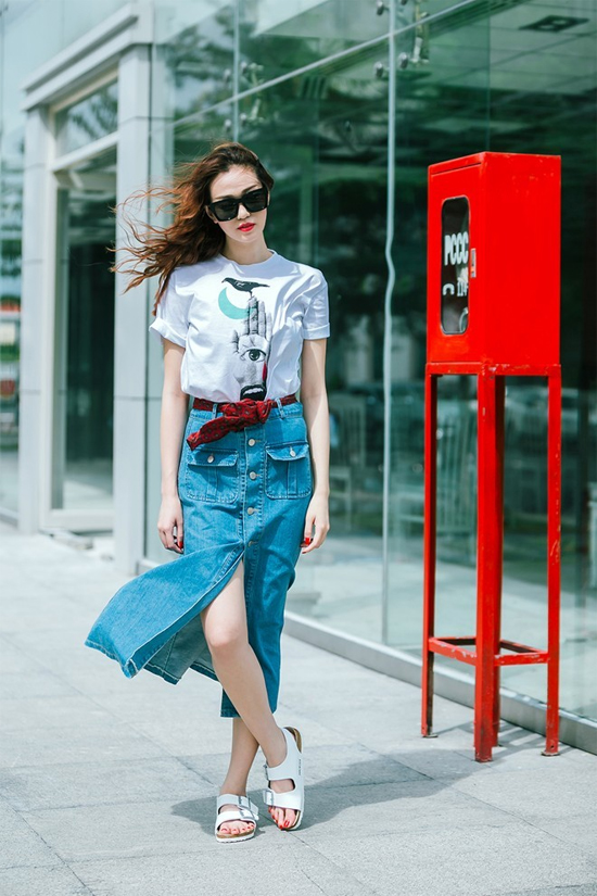 Khánh My gợi ý cho các cô nàng dáng người cao ráo và muốn khoe đôi chân gợi cảm chiếc chân váy denim midi, cài khuy xẻ trước kết hợp áo phông họa tiết ngộ nghĩnh. Chiếc khăn làm điểm nhấn thắt eo, sơ vin sẽ khiến chủ nhân rất thú vị và hấp dẫn.