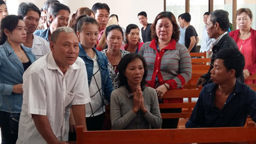 Bà Tuyết (người chắp tay) cùng người thân tại phiên tòa tranh chấp với đại lý vé số Triều Phát - Ảnh: Xuân Lam