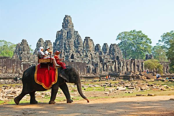 
Một nhóm du khách ngồi trên lưng voi khi tham quan đền Angkor Wat.
