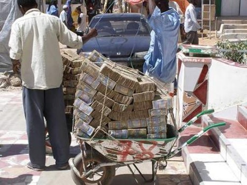 
Người dân Zimbabwe chở tiền bằng xe cút kít đi chợ. Ảnh: Palpa India
