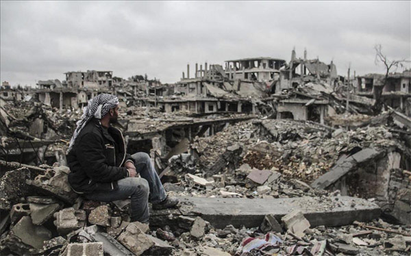 Trong bức ảnh chụp ngày 12/3, một người đàn ông ngồi nhìn đống đổ nát của các tòa nhà bị phá hủy trong các vụ đọ súng giữa tổ chức Nhà nước Hồi giáo (IS) và các nhóm vũ trang người Kurd ở giữa thị trấn Kobani, Syria. (Ảnh: Reuters)