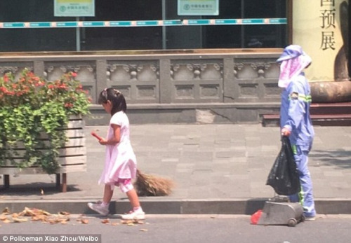 
Cô bé phụ giúp mẹ mình quét dọn đường phố Thượng Hải.
