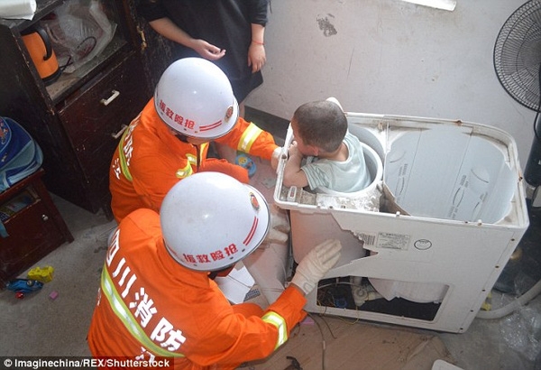 Đội cứu hỏa sử dụng thiết bị chuyên dụng để tháo dỡ chiếc máy giặt.