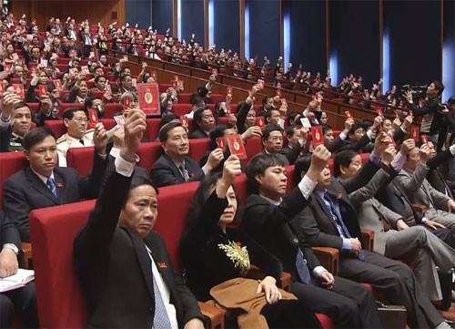 C&aacute;c đại biểu biểu quyết th&ocirc;ng qua nghị quyết đại hội XII của Đảng.
