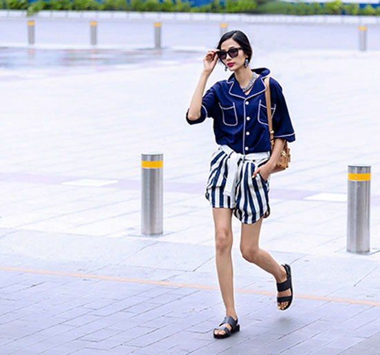 Hoàng Thùy là một trong những siêu mẫu sở hữu gu thời trang đẹp chẳng kém những fashionista thế giới. Cô tự tin khoe dáng trong chiếc áo sơ mi pijama và quần short kẻ sọc. Style rất đáng cho giới trẻ học hỏi vào những ngày đi dạo phố mùa hè.