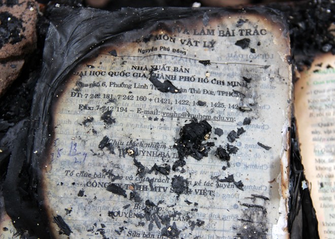 Trong nhà thầy Tiên có nhiều vật dụng dễ cháy. Trong ảnh là sách và tài liệu môn Vật lý còn sót lại nhưng cũng bị cháy xém. Ảnh: Việt Tường.