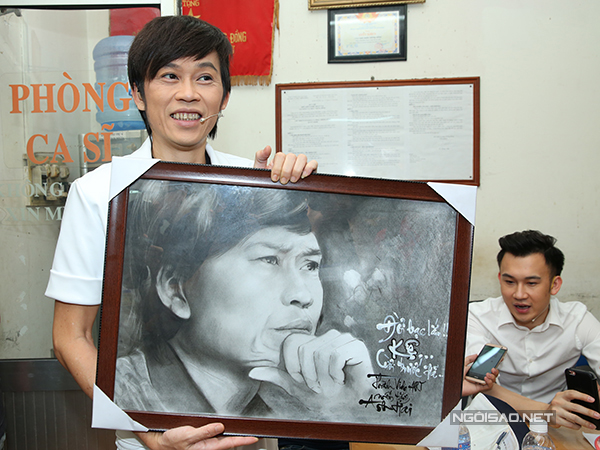 Ở hậu trường, Hoài Linh thích thú khoe bức tranh anh được tặng, trong khi Dương Triệu Vũ được báo chí phỏng vấn.