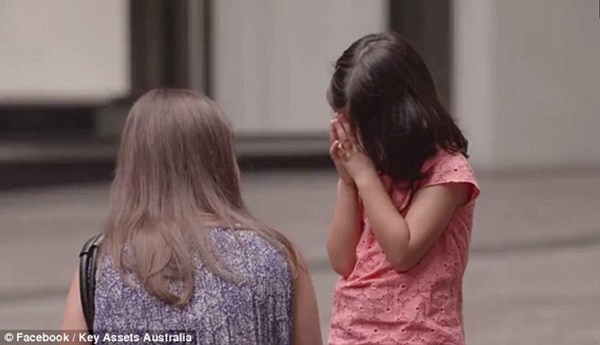 
Một người phụ nữ dừng lại hỏi thăm khi thấy bé gái vùi mặt vào tay.
