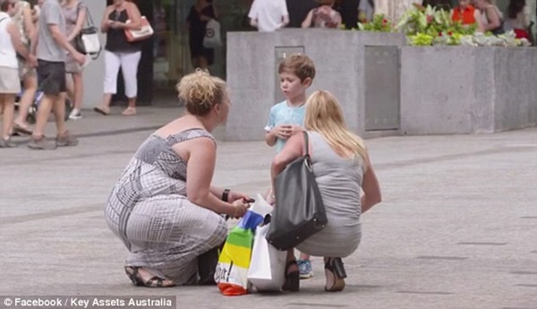 
Hai người phụ nữ đang đi mua sắm dừng lại hỏi chuyện bé trai.

