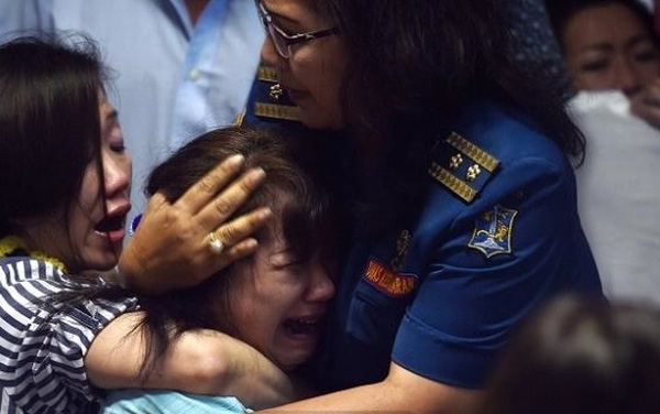 
Người thân của các nạn nhân trên chuyến bay QZ8501 an ủi nhau sau khi nghe tin buồn. Ảnh: AFP.
