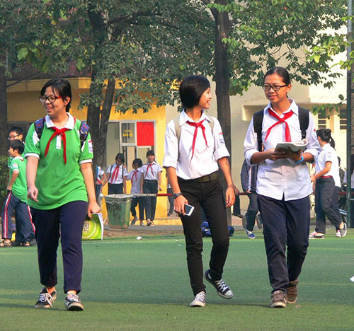 Bức ảnh bé Kiến (giữa) đeo khăn đỏ đi lại giữa sân trường
