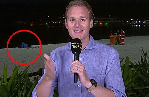 
H&igrave;nh ảnh nhạy cảm của cặp t&igrave;nh nh&acirc;n ph&iacute;a sau lưng ph&oacute;ng vi&ecirc;n Dan Walker. Ảnh:BBC
