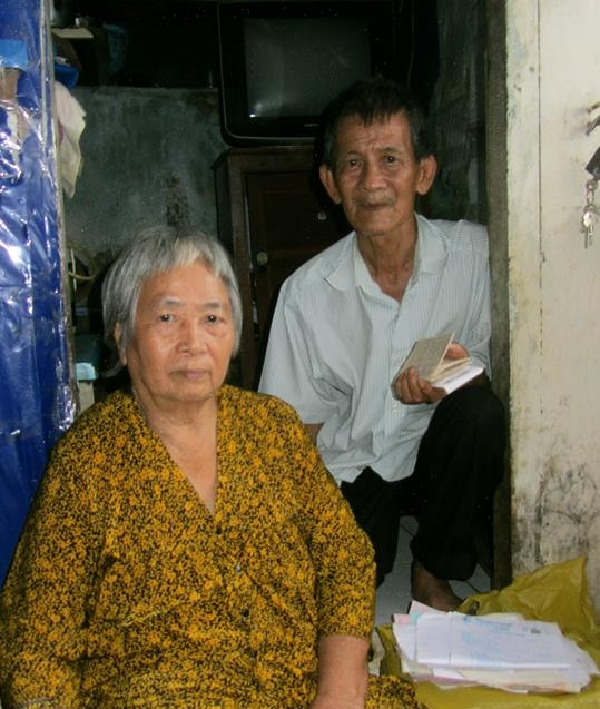Cụ Tá (phải) bên người vợ bại liệt. Ảnh: Lê Nguyễn
