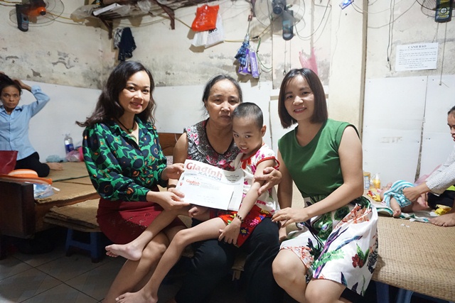 Bà Đỗ Thị Thúy , đại diện chuyên mục Vòng tay Nhân ái Báo GĐ&XH (bên trái) trao tiền cho mẹ con cháu Phúc Liên. Ảnh: Mai Nguyễn