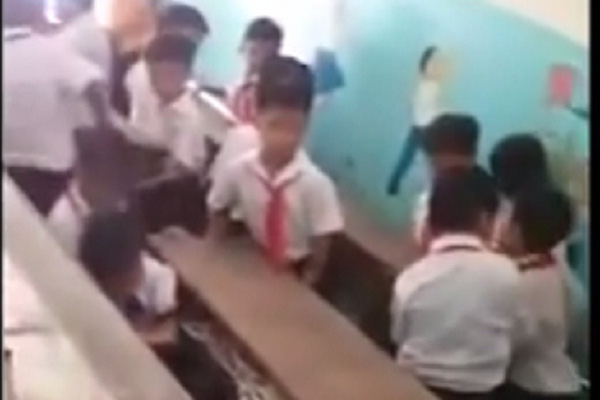 Học sinh lớp 4 Trường tiểu học Phước Đồng khiêng bàn nặng từ trên tầng xuống. Ảnh cắt từ clip
