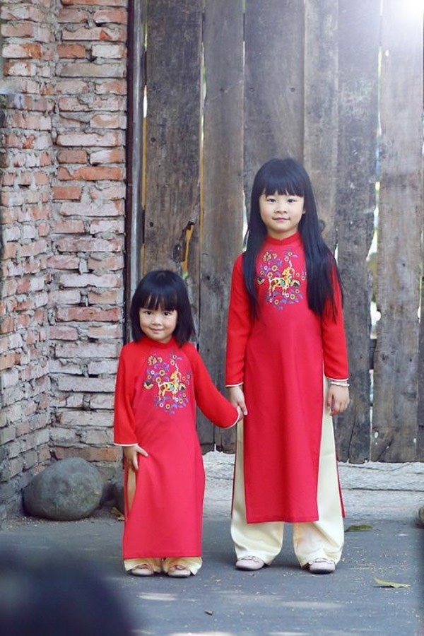 Hai cô công chúa của nam diễn viên Bình Minh và Anh Thơ xinh xắn vô cùng trong hai bộ áo dài đỏ giống nhau, bộ áo của hai bé mang đậm không khí Tết tươi vui.