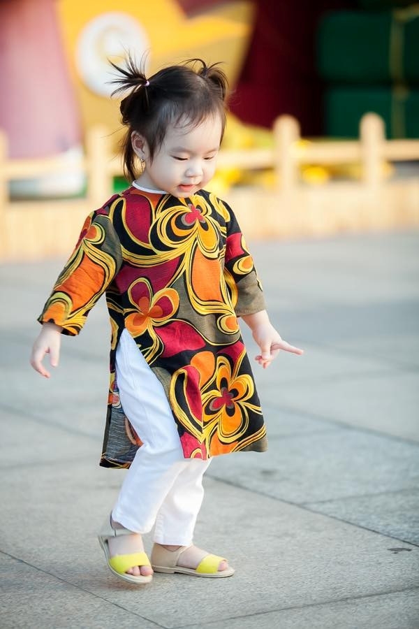Vợ của nam ca sĩ Lý Hải - Minh Hà - cũng chia sẻ hình ảnh các con trong trang phục truyền thống. Công chúa thứ hai nhà Lý Hải Sunny - tên thật là Nguyễn Tuệ Minh - được mẹ lựa chọn cho tà áo dài màu sắc rực với hoạ tiết hoa to bản nổi bật.