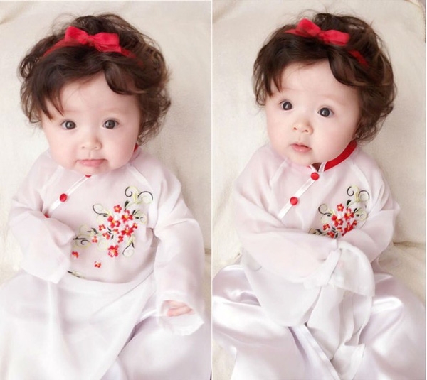 Cadie Mộc Trà cũng được mẹ Elly Trần diện áo dài trắng điểm xuyết hoa nhỏ xinh xắn. Biểu cảm đáng yêu của công chúa nhỏ trong trang phục truyền thống khiến các fan thích thú.