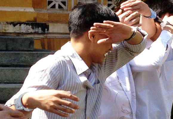 Nguyễn Văn Hoài xấu hổ lấy tay che mặt để tránh ánh mắt của mọi người.