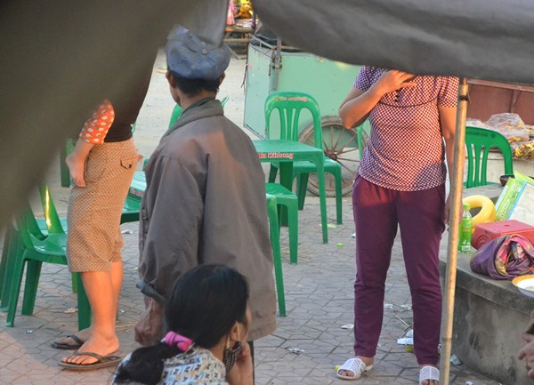 Bị PV truy vấn, người đàn ông này đứng dậy bỏ đi và nói chuyện với người quen đang bán hàng ngay cổng chùa, sau đó đi về phía trong làng.