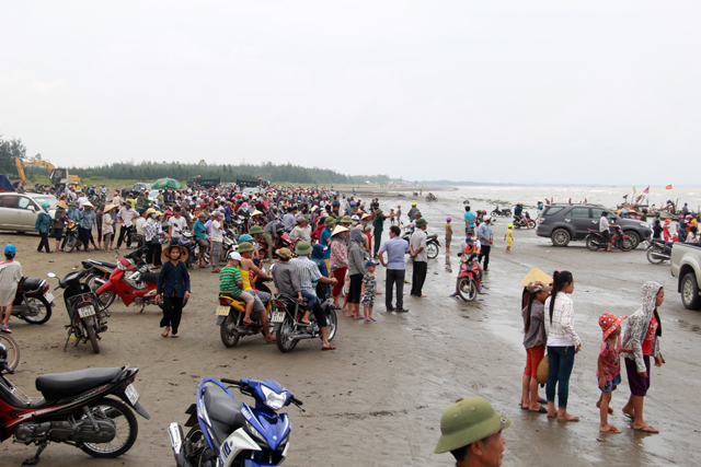 Dù thời tiết nắng nóng, rất đông người dân vẫn tập trung trên bãi biển giữa trưa để chờ xem lực lượng chức năng kéo cá voi vào bờ