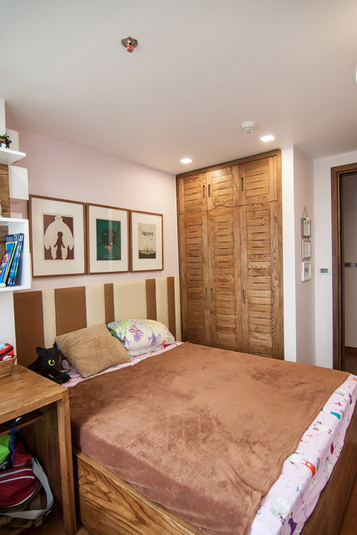 Phòng ngủ nhỏ được thiết kế tận dụng diện tích, giữ phong cách tổng thể của căn hộ, thêm vài chi tiết màu sắc tươi trẻ.
