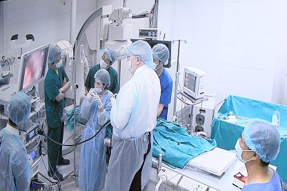 
GS Leroy trực tiếp cầm tay chỉ việc, hướng dẫn cho các bác sĩ BV Xanh Pôn thực hiện ca phẫu thuật nội soi (Ảnh chụp màn hình)
