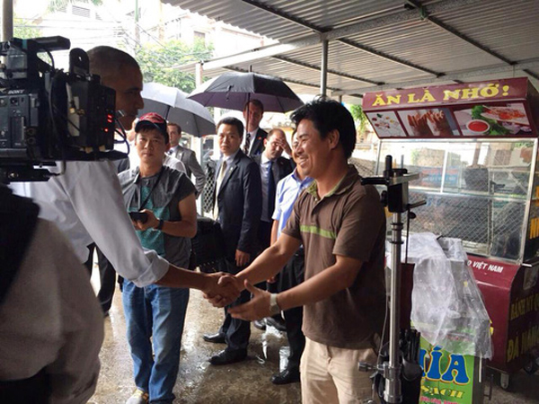 
Được biết ngoài đến thăm người dân xung quanh khu vực Mễ Trì, Tổng thống Barack Obama còn đội mưa để mua bằng được đặc sản cốm của Hà Nội. Ảnh Người lao động

 
